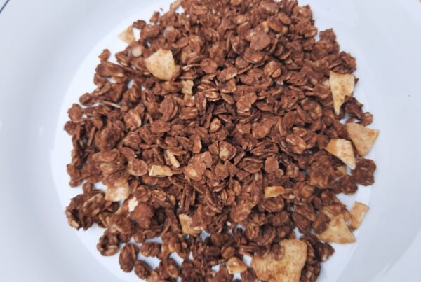 Close-up of granola clusters made from rolled oats, cashews, dried banana pieces and dark chocolate